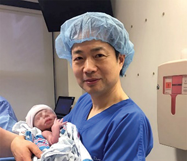 John Zhang holds the baby