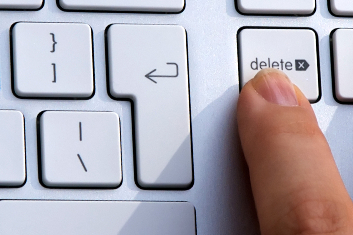 a finger presses a delete button