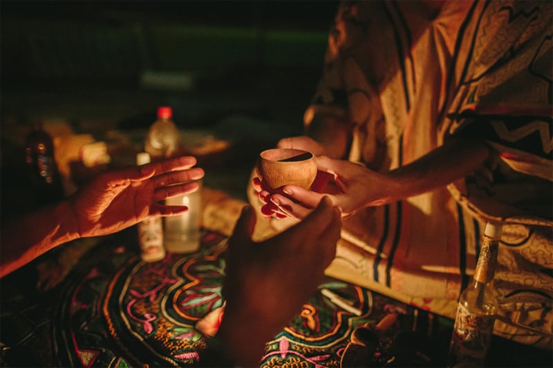 A man being handed ayahuasca